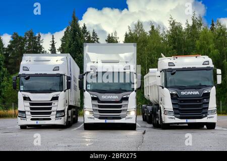 Weiße Scania-Transportwagen, von links R410, Scheinwerfer G500 an, R650 auf Hof geparkt. Scania in Finnland 70 Jahre Tour. Turku, Finnland. August 23, 2019. Stockfoto