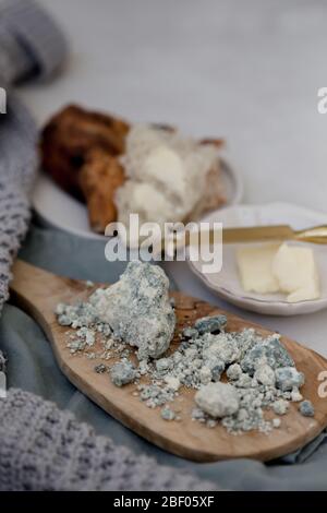 Vertikales Bild von blauem Lammkäse auf einem hölzernen Olivenbrett mit negativem Raum in der oberen rechten Ecke des Bildes platziert. Stockfoto