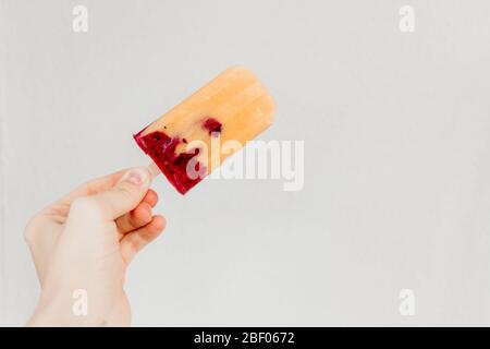 Obst hausgemachte Popsicle hergestellt ist aus frischer Mango, schwarze Johannisbeere und Kokosmilch. Minimalistischer Fotostil. Stockfoto