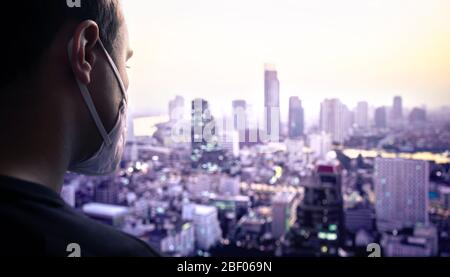 Mann, der in der Stadt eine Maske trägt, um vor Verschmutzung oder Influenza-Infektion zu schützen. Coronavirus oder Smog Konzept. Verschmutzte schlechte Luftqualität in Asien. Stockfoto