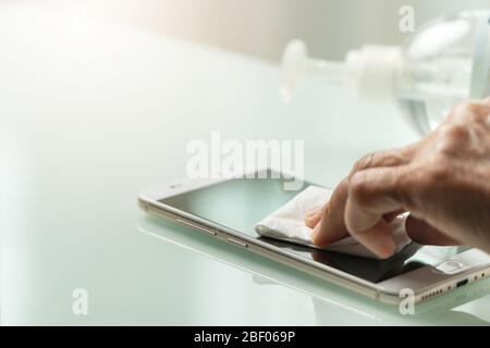 Covid-19 Coronavirus Handreinigungs Smartphone Konzept, Senior Handwisch Smartphone mit Alkohol Gel oder Anti-Bakterien-Gel, um Reinigung und klar V Stockfoto