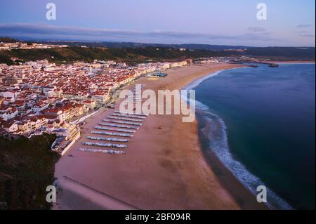 Blick am Ende des Tages über die Stadt und den Strand von Nazaré Stockfoto