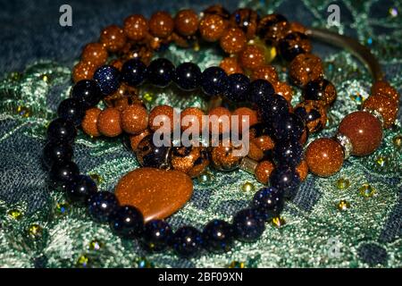 Boho besteierte Armbänder mit braunen und dunkelblauen Glitter-Glassteinen. Stockfoto