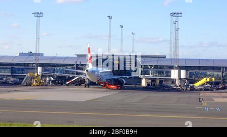 KOPENHAGEN, DÄNEMARK - JUL 06th, 2015: Laden Flugzeug geparkt von Kopenhagen Flughafengebäude, Treppen und Gepäckträger in der Nähe Stockfoto