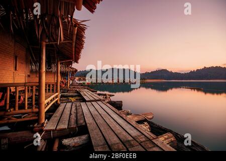 Schwimmende Bungalows im Khao Sok Nationalpark mit Cheow Lan See und Bergen bei Sonnenaufgang, Thailand. Stockfoto