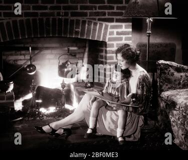 1920ER-MUTTER UND TOCHTER SITZEN ZUSAMMEN AUF DEM BODEN VOR WARMEM FEUER IM KAMIN LESUNG EIN MÄRCHENBUCH MÄDCHEN AUF DEM SCHOSS DER MUTTER - F2263 HAR001 HARS ALTE MODE JUGENDLICHE KOMMUNIKATION JUNGE ERWACHSENE SCHLAFENSZEIT STARKE FAMILIEN FREUDE LIFESTYLE BACKSTEIN FRAUEN LÄNDLICHEN LEBENS KOPIEREN RAUM FREUNDSCHAFT HALBLÄNGE DAMEN TÖCHTER PERSONEN INSPIRATION PFLEGE WARM GELASSENHEIT VERTRAUEN WASSERKOCHER B & W RUNDE VOR TRÄUMEN HOCHWINKEL ABENTEUER FREIZEIT UND STORYBOOK VERBINDUNG KONZEPTIONELLE WÄRME GEMÜTLICH FLUCHT PHANTASIE RELATED STILVOLLE UNTERSTÜTZUNG PERSÖNLICHE BINDUNG ZUNEIGUNG ZUSAMMENARBEIT EMOTION WACHSTUM JUGENDLICHE MÜTTER ENTSPANNUNG Stockfoto