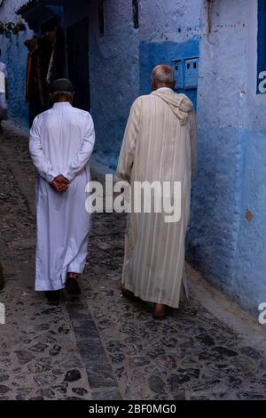 Chefchaouen, Nordmarokko, 10. Juni 2016. Zwei älteste, in traditioneller marokkanischer Kleidung, spazieren auf einer der Straßen der blauen Stadt. Stockfoto