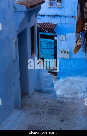 Chefchaouen, die blaue Stadt, Nord-Marokko, 10. Juni 2016. Ein Kind vor seinem Haus spielt. Stockfoto