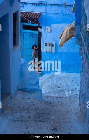 Chefchaouen, die blaue Stadt, Nord-Marokko, 10. Juni 2016. Ein Kind außerhalb seines Hauses, beobachtet. Stockfoto