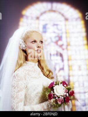 1960ER BLONDE FRAU BRAUT TRAGEN SPITZE BRAUTKLEID NET SCHLEIER MIT ROTEN UND WEISSEN BOUQUET VOR GLASFENSTER - KB9221 PHT001 HARS VERHEIRATET STUDIO SCHUSS VERANSTALTUNG KOPIEREN RAUM VOLLER LÄNGE DAMEN EHE PERSONEN SCHLEIER VERTRAUEN ZEREMONIE BRAUT TRÄUME BRAUT RELIGIÖSEN BRAUCH UND TRADITION HOCHZEITLICHE NUPTIALS GELEGENHEIT HEIRATEN STOLZ KOPFSTÜCK RITUS DER PASSAGE STILVOLL WED TREU GLAUBEN SUCHEN HEIRATEN EHE JUNGE ERWACHSENE FRAU GLAUBEN KAUKASISCHE ETHNIE ALTMODISCH Stockfoto