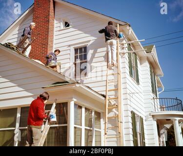 1970ER VIER MÄNNER AUF LEITERN UND DACH MALEREI VORSTADTWEISSE HOLZSPLATTEN HAUS MIT DUNKELGRÜNEN FENSTERLÄDEN AN KÜHLEN SONNIGEN TAG - KP2314 SHE001 HARS HOME LIFE COPY SPACE FULL-LENGTH HALF-LENGTH PERSONEN WOHN MÄNNER RISIKO GEBÄUDE BERUF SONNIGES DACH FÄHIGKEIT BERUF FÄHIGKEITEN KUNDENDIENST UND KARRIERE EXTERIOR NIEDRIGEN WINKEL AUF HÄUSER LEITERN BERUFE KONZEPTIONELLE RESIDENZ UNTERSTÜTZUNG KLAPBOARD MITTE ERWACHSENE MITTE ERWACHSENE MANN JUNGE ERWACHSENE MANN KAUKASISCHE ETHNIE ALTMODISCHE FENSTERLÄDEN Stockfoto
