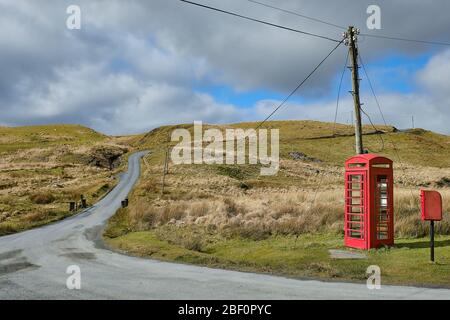 Alte ländliche Telefonzentrale und Briefkasten neben einer einspurigen Straße in den Cambrian Mountains von Mid Wales Stockfoto