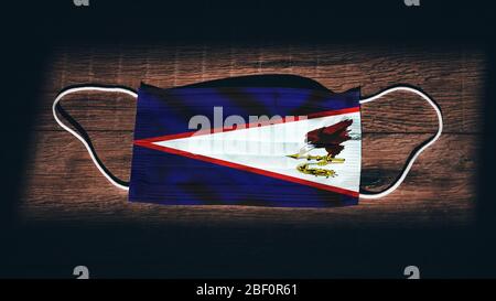 Flagge Von Amerikanisch-Samoa. Coronavirus Covid 19 im US-Bundesstaat. Medizinische Maske isolieren auf schwarzem Hintergrund. Gesicht- und Mundschutz zum Schutz vor Airbo Stockfoto