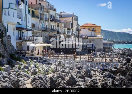 Häuser am Meer von einem Pfad auf einem felsigen Ufer in Cefalu Stadt, an der Tyrrhenischen Küste von Sizilien, Italien, gesehen Stockfoto