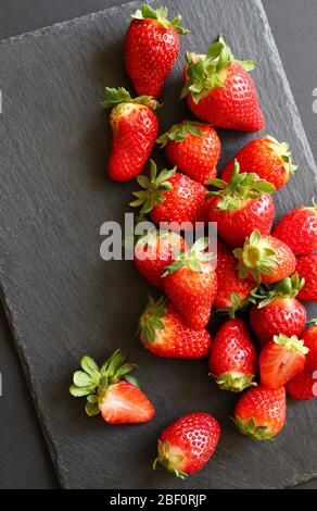 Viel frische Erdbeeren auf dunklem Hintergrund. Draufsicht. Konzept der gesunden Früchte. Stockfoto