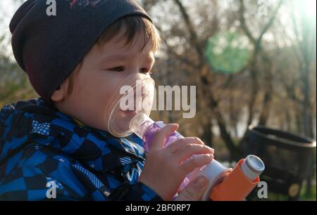 Ein kleiner Junge, der an Krankheit leidet Asthma bronchiale bekommen Behandlung mit Aerosol-Inhalator. Vermeidung von Komplikationen Stockfoto