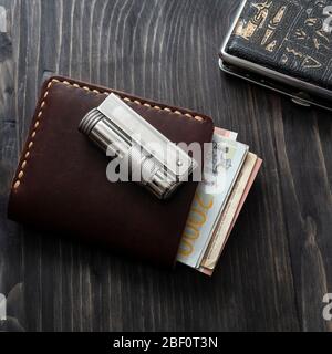 Zigarettenanzünder und Leder Brieftasche auf einem hölzernen Hintergrund, Retro-Stil Vintage-Ton Stockfoto