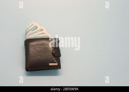 Leder braune Brieftasche mit russischem Geld, das in Banknoten aus ihm herausragt Stockfoto