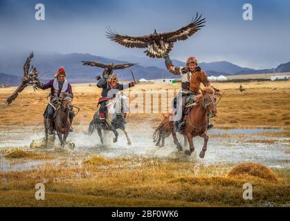 Mongolischer Adlerjäger, drei Kasachen zu Pferd mit ausgebildeten Adlern, Bajan-Oelgii Provinz, Mongolei Stockfoto