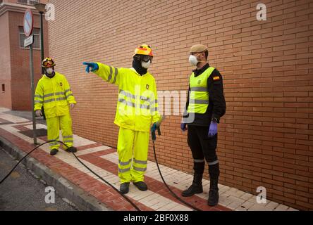 Vor der Desinfektion stehen ein Feuerwehrmann und ein Mitglied der spanischen Armee im militärischen Notfall (Ume) in Schutzanzügen vor dem Gesundheitszentrum. Mitglieder der spanischen Armee-Notaufnahme (Ume) und Feuerwehrleute desinfizieren ein Gesundheitszentrum nach der von der spanischen Regierung erlassenen Haft, die bis zum 10. Mai verlängert wird. Stockfoto