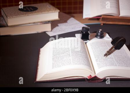 Alte Bücher, Stift und Tinte auf dem Tisch Stockfoto