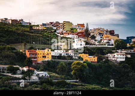 Bunte Häuser auf einem terrassenförmig angelegten Hügel in der Nähe von Icod de los Vinos Dorf im Norden von Teneriffa, Kanarische Inseln, Spanien an einem bewölkten Winternachmittag Stockfoto