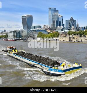 Flusstransport lange Barge & Ladung Erde aus Thames Tideway Tunnel Kanalisation Projekt gegraben durch Schlepper durch City of London Skyline England UK geschoben Stockfoto