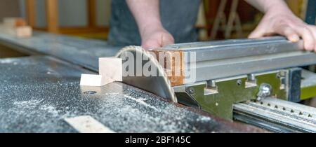 Zimmermann schneidet Holzplanke auf Kreissäge Stockfoto