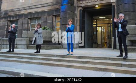 (Von links nach rechts) Malcolm Wright Generaldirektor NHS Schottland, Gesundheitsministerin Jeane Freeman, erster Minister Nicola Sturgeon und Dr. Gregor Smith Schottlands interimistischer Chefarzt applaudieren vor dem St. Andrew's House, dem Hauptquartier der schottischen Regierung in Edinburgh, Die lokalen Helden während der landesweiten Initiative „Clap for Carers“ am Donnerstag zu würdigen und zu unterstützen, die NHS-Arbeiter und Pförter gegen die Coronavirus-Pandemie anerkennt und bekämpft. Stockfoto