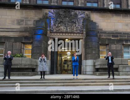 (Von links nach rechts) Malcolm Wright Generaldirektor NHS Schottland, Gesundheitsministerin Jeane Freeman, erster Minister Nicola Sturgeon und Dr. Gregor Smith Schottlands interimistischer Chefarzt applaudieren vor dem St. Andrew's House, dem Hauptquartier der schottischen Regierung in Edinburgh, Die lokalen Helden während der landesweiten Initiative „Clap for Carers“ am Donnerstag zu würdigen und zu unterstützen, die NHS-Arbeiter und Pförter gegen die Coronavirus-Pandemie anerkennt und bekämpft. Stockfoto