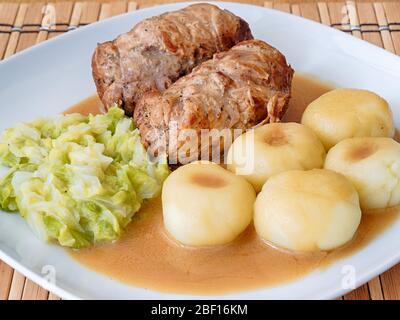 Schlesische Knödel mit Schweinefleisch Roulade und Kohl in Rostsoße Stockfoto