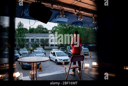 Oberhausen, Deutschland. April 2020. Der Komiker David Werker tritt mit seinem Programm 'Suddenly Serious' auf. Das Theater an der Niehburg in Oberhausen bietet ein Drive-in-Kino. Künstler treten auf einer Bühne auf einem Parkplatz vor den Zuschauern in Autos auf. Quelle: Fabian Strauch/dpa/Alamy Live News Stockfoto