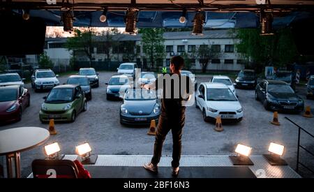 Oberhausen, Deutschland. April 2020. Der Komiker David Werker tritt mit seinem Programm 'Suddenly Serious' auf. Das Theater an der Niehburg in Oberhausen bietet ein Drive-in-Kino. Künstler treten auf einer Bühne auf einem Parkplatz vor den Zuschauern in Autos auf. Quelle: Fabian Strauch/dpa/Alamy Live News Stockfoto