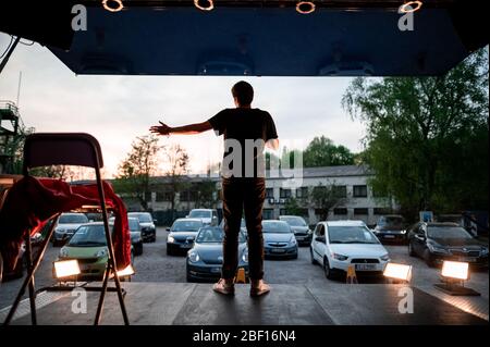 Oberhausen, Deutschland. April 2020. Der Komiker David Werker tritt mit seinem Programm 'Suddenly Serious' auf. Das Theater an der Niehburg in Oberhausen bietet ein Drive-in-Kino. Künstler treten auf einer Bühne auf einem Parkplatz vor den Zuschauern in Autos auf. Quelle: Fabian Strauch/dpa/Alamy Live News Stockfoto