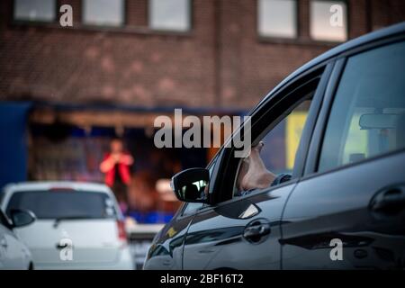 Oberhausen, Deutschland. April 2020. Ein Zuschauer hört sich das Programm 'Suddly Serious' an. Das Theater an der Niehburg in Oberhausen bietet ein Drive-in-Theater. Künstler treten auf einer Bühne auf einem Parkplatz vor den Zuschauern in Autos auf. Quelle: Fabian Strauch/dpa/Alamy Live News Stockfoto