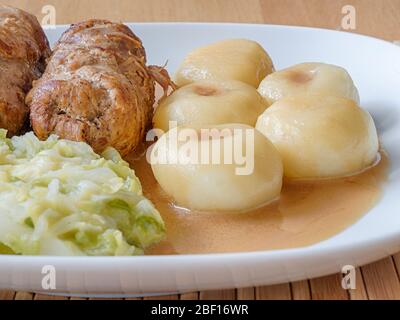 Schlesische Knödel mit Schweinefleisch Roulade und Kohl in Rostsoße Stockfoto