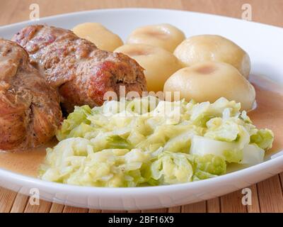 Schlesische Knödel mit Schweinefleisch Roulade und Kohl in Rostsoße Stockfoto