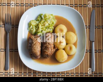 Schlesische Knödel mit Schweinefleisch Roulade und Kohl in Rostsoße Stockfoto