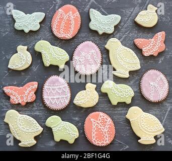 Oster-Lebkuchen-Plätzchen mit verschiedenen Verzierungen auf grauem Hintergrund. Stockfoto