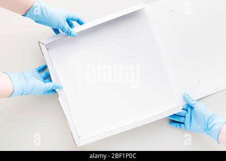 Leere Pappschachtel Pizza Verpackung und Hände in medizinischen chirurgischen Handschuhen für Quarantäne Stockfoto