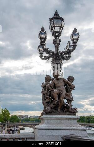 Kunstvolle klassizistische Straßenbeleuchtung mit drei Cherub auf der Brücke Alexandre III, Paris/Frankreich Stockfoto