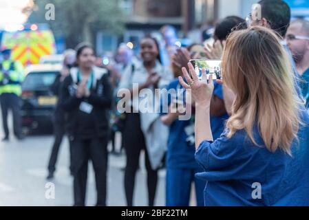 Krankenschwester fotografiert Klatschen bei Clap für Betreuer um 20 Uhr außerhalb Southend Hospital am Abend danken NHS und Schlüsselarbeiter während des COVID-19 Coronavirus Stockfoto