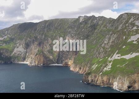 Meeresklippen und kleiner Sandstrand am Fuße der Klippen in Irland bei Slieve League am Frühsommer Juni Tag, County Donegal, Irland. Stockfoto