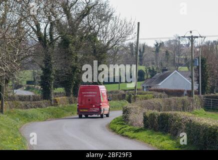 Zurück von Royal Mail Paketforce roten Transit-Van unterwegs entlang ländlichen Landstraße in Nordirland macht Paketzustellung während der Sperrung April 20 Stockfoto