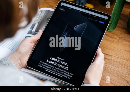 Paris, Frankreich - Apr 16, 2020: Frau auf der Apple Computers Internet-Website auf iPad Pro Tablet in Raumumgebung präsentiert neue angekündigt im april 2020 iPhone SE Smartphone Stockfoto