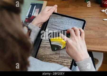 Paris, Frankreich - 16. April 2020: Neugierige Frau auf Apple Computers Internet-Website auf iPad Pro Tablet neue iPhone SE Inspektion auf Augmented Reality Display Stockfoto