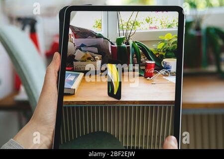 Paris, Frankreich - 16. April 2020: Neugierige Frau auf Apple Computers Internet-Website auf iPad Pro Tablet neue iPhone SE Inspektion auf Augmented Reality Display Stockfoto