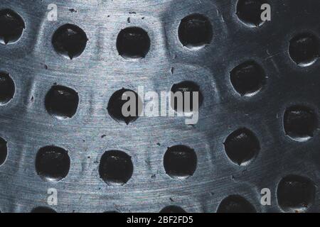 Stahlplatte mit Löchern aus nächster Nähe. Abstrakter industrieller Hintergrund. Raue Metalloberfläche Stockfoto