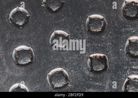 Stahlplatte mit Löchern aus nächster Nähe. Abstrakter industrieller Hintergrund. Raue Metalloberfläche Stockfoto