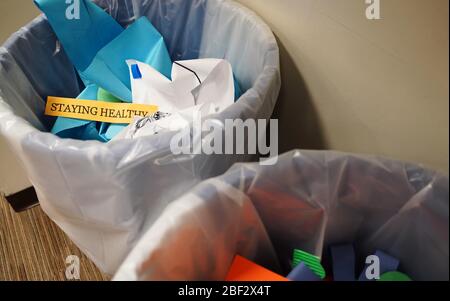 Verschrottete Reste einer Pinnwand, die in einem Studentenwohnheim "gesund" im Müll aussagt Stockfoto